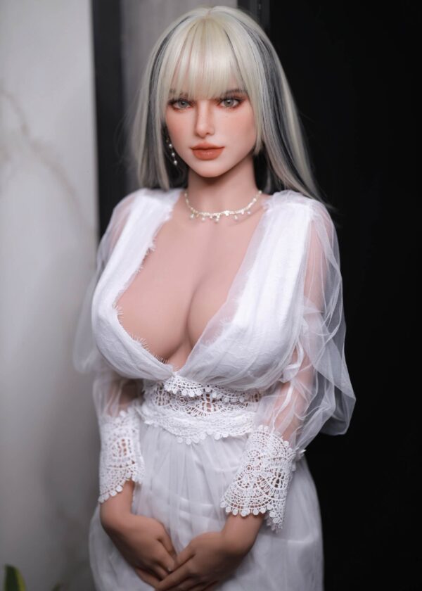 Üppige, vollbusige Blondine mit engelsgleichem Aussehen. Im weißen Kleid.